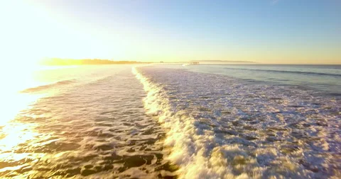 Waves Towards Pier At Sunrise. Low flight. 4k Aerial Stock Footage 145176874
