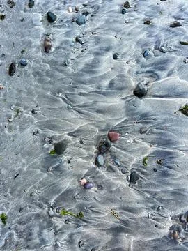 Waves traces on grey sandy beach Stock Photos