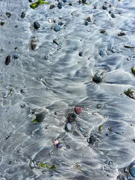 Waves traces on grey sandy beach Stock Photos