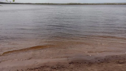 Waves of the Volga river run evenly on the sandy shore Stock Footage 129902404