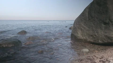 Waves wash over a large boulder. Coast of the Baltic Sea. Vídeos de archivo 142198229