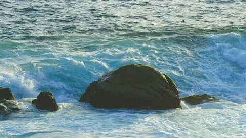 Waves wash over a large rock in ocean during sunset in slow motion RED camera Stock-Footage 123565716