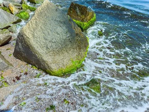 Waves wash over large rocks along the shore at a coastal location during da.. Stock Photos