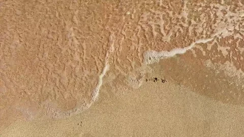 Waves wash over sandy beach, erasing the word summer written in the sand, showca Stock Footage 332324372