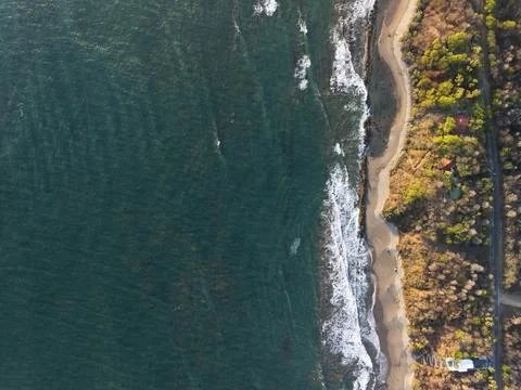 Waves wash over sandy beach by the coast Foto stock