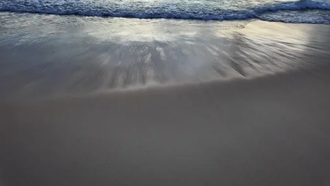 Waves wash the sand on the beach during sunset in Asia Stock Footage 310957073