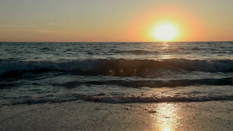 Waves wash sandy beach at sunset Video stock 154503734