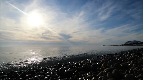 Waves wash the stone seashore in the rays of the bright sun Stock Footage 132667411