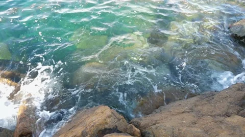 The waves washed over the rocks on the shore. Blue clear water surface 스톡 동영상 153741605