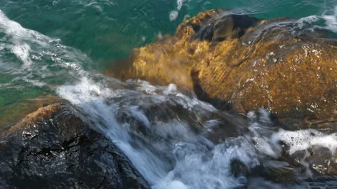 The waves washed over the rocks on the shore. Blue clear water surface 스톡 동영상 153741905