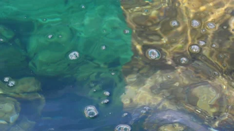 The waves washed over the rocks on the shore. Blue clear water surface 스톡 동영상 153741934