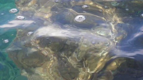 The waves washed over the rocks on the shore. Blue clear water surface 스톡 동영상 153742045