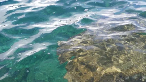 The waves washed over the rocks on the shore. Blue clear water surface 스톡 동영상 153742411