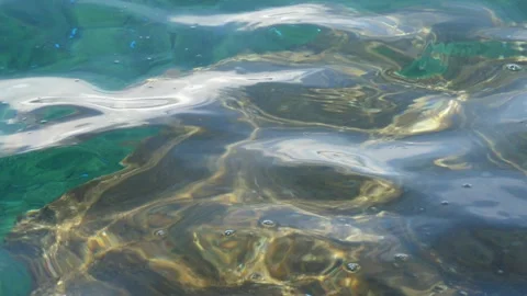 The waves washed over the rocks on the shore. Blue clear water surface 動画素材 153742982