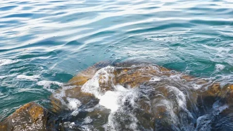 The waves washed over the rocks on the shore. Blue clear water surface 動画素材 153743276