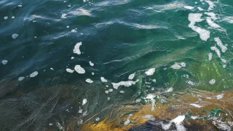The waves washed over the rocks on the shore. Blue clear water surface 動画素材 153743327