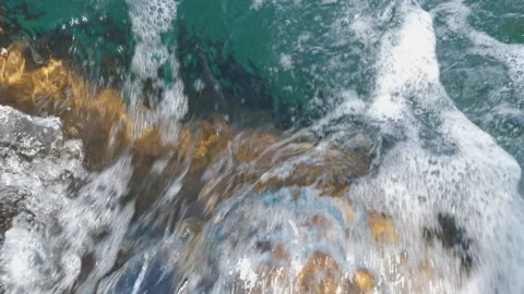 The waves washed over the rocks on the shore. Blue clear water surface 動画素材 153743646