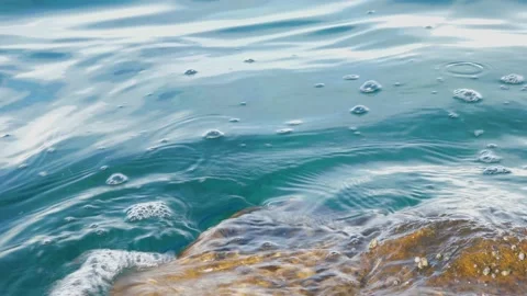 The waves washed over the rocks on the shore. Blue clear water surface 動画素材 153744674