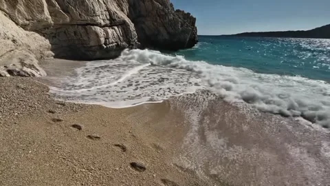 Waves washing away footprints on sandy beach in Kaputas Turkey  Kas, Turkey, Stock Footage 331196523