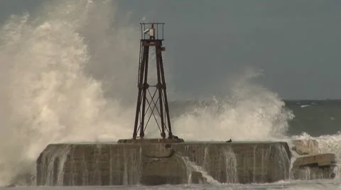 Waves washing up near small lighthouse Stock Footage 8509747