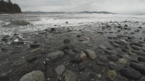 Waves washing over beach rocks during storm Stock Footage 122408895