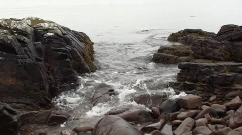 Waves washing over rocks on a sandy beach Stock Footage 44334902