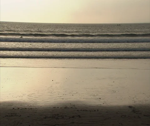 Waves washing up on shore, kid rides bicycle in wet sand Stock Footage 86747191