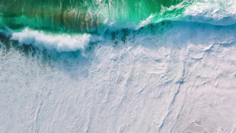 Waves of water of Pacific ocean or sea meet sandy beach during high tide, aerial Stock Footage 202290155