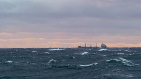 Waves with white foam and a ship on the horizon in a storm Stock Footage 271176906