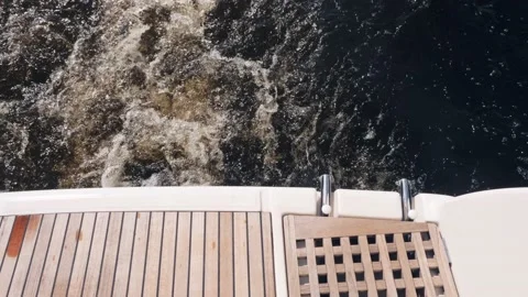 Waves with white foam forming behind yacht with wooden stern Video stock 138728096