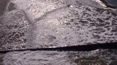 Waves with white foam roll on empty ocean beach on sunny day Stock Footage 148568661