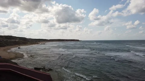Waves with white foam. Top view. blue sea. Sandy beach with stones, boulders. Stock Footage 139441836