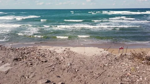 Waves with white foam. Top view. blue sea. Sandy beach with stones, boulders. Vidéo 139441844