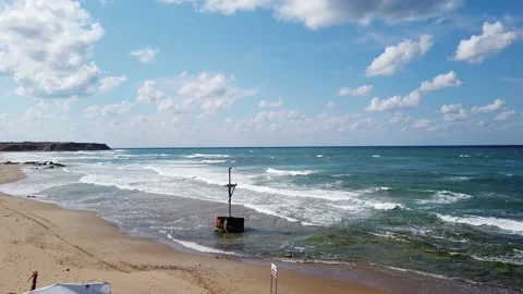 Waves with white foam. Top view. blue sea. Sandy beach with stones, boulders. Stock Footage 139441848