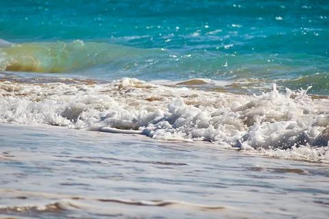 Waves with white spray on the beach Stock Photos