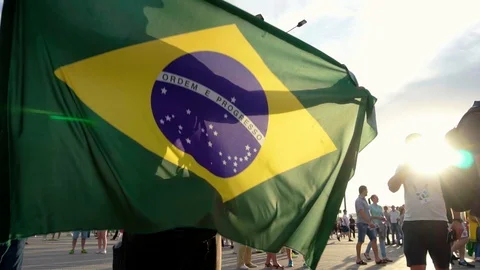 Waving Brazilian National Flag on the hands of a fan. Slow motion footage. Stock Footage