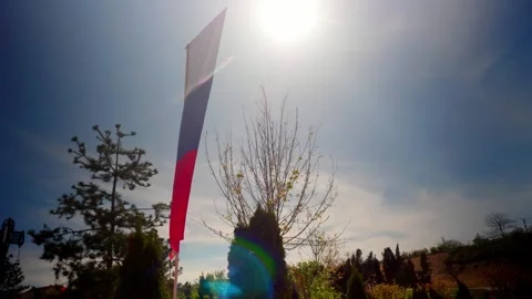 Waving flag against a bright blue sky Stock Footage 335353374