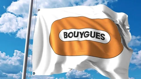 Waving flag with Bouygues logo against clouds and sky. 4K editorial animation Stock Footage