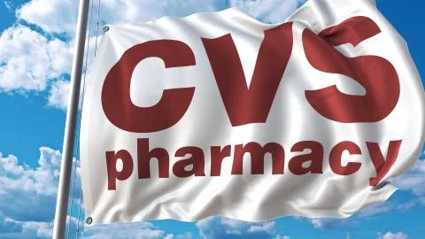 Waving flag with Cvs Pharmacy logo against sky and clouds. Editorial 3D Stock Illustration