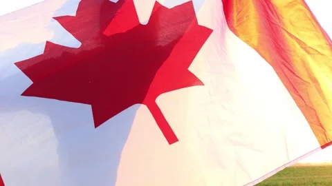 Waving flag at sunset over vibrant Canadian landscape celebrates heritage Stock Footage 295257984