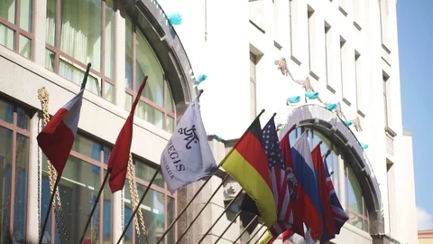 Waving flags in front of building. World Flags in front of historic European Stock Footage 83186202