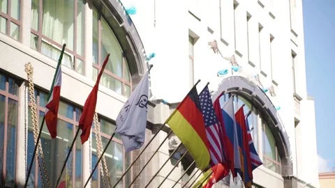 Waving flags in front of building. World Flags in front of historic European Stock Footage 83186207