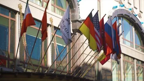 Waving flags in front of building. World Flags in front of historic European Stock Photos