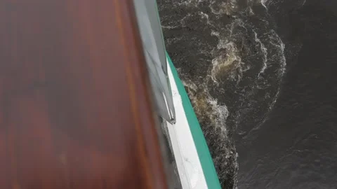 Waving grey river water appears from behind boat handrail Stock Footage 155286442