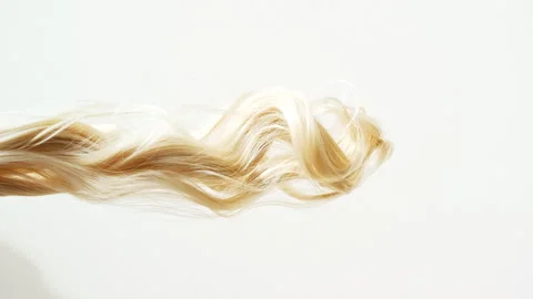 Waving of locks of blond shiny wavy bunch hair. Slow Motion. Hair care and Stock Footage 255672865