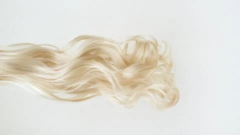 Waving of locks of blond shiny wavy bunch hair. Slow Motion. Hair care and Stock Footage 272592643