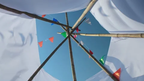 Waving small colorful flags hanging on the rope for holidays against blue sky. Stock Footage 228713969