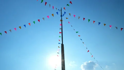 Waving small colorful flags hanging on the rope for holidays against blue sky. Stock Footage 228714671