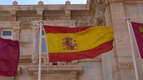Waving Spanish Flag in Front of Ornate Historic Building Stock Footage 346254971