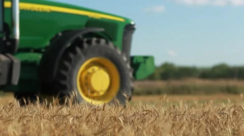 Waving Wheat in front of a Tractor Vídeo Stock 60040323